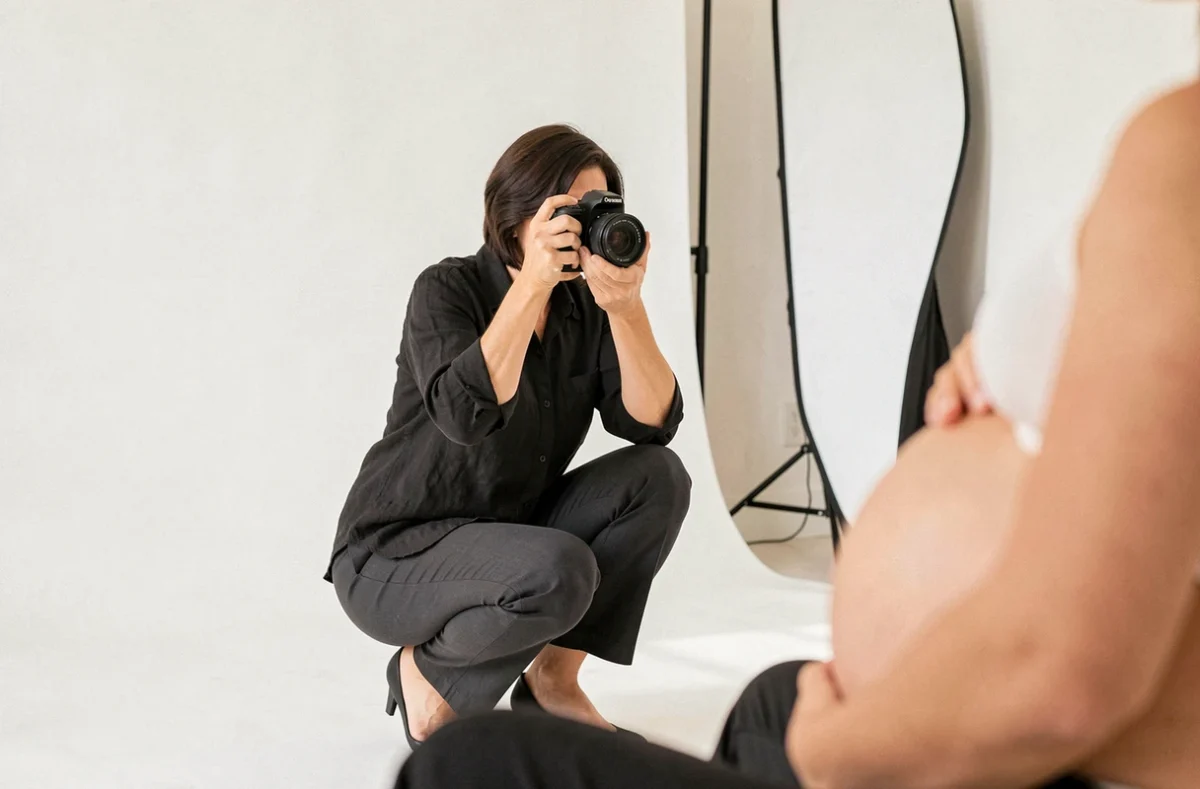 Photographe professionnelle en action lors d'une séance photo de grossesse en studio, comment choisir son photographe de maternité